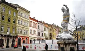  ?? AFP ?? Ukrainian servicemen walk past wrapped statues at the Archcathed­ral Basilica of the Assumption of the Blessed Virgin Mary, also known as Latin Cathedral in Lviv western Ukraine on March 5.