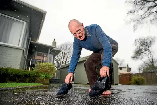 ?? PHOTO: SIMON O’CONNOR/STUFF ?? Bruno Egli picks up a pair of slippers dropped off to his Frankleigh Park home by a cat.