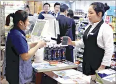  ?? HIDEO KAMATA/THE YOMIURI SHIMBUN ?? A woman makes a purchase at a Lawson convenienc­e store in Shanghai on June 6.