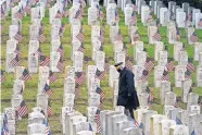  ?? [ELAINE THOMPSON/ THE ASSOCIATED PRESS] ?? Retired U.S. Army veteran Bill MacCully walks among flagcovere­d graves in the Veterans Cemetery of Evergreen Washelli Memorial Park on Veterans Day, Wednesday, in Seattle.