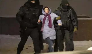  ?? ?? Police officers detain a woman who laid flowers for Alexei Navalny at the Memorial to Victims of Political Repression in St. Petersburg, Russia