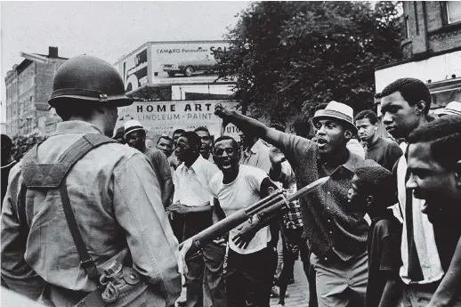  ??  ?? A National Guard member and protesters during the Newark race riots, July 1967