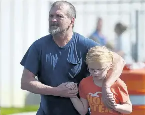  ?? RAINIER EHRHARDT/ASSOCIATED PRESS ?? Joey Taylor walks with his daughter Josie Taylor after picking her up at Oakdale Baptist Church on Wednesday, in Townville, S.C. A teenager opened fire at the South Carolina elementary school Wednesday.