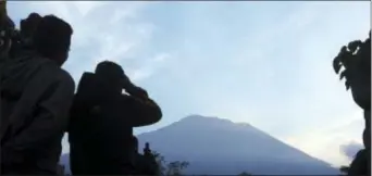  ?? FIRDIA LISNAWATI — THE ASSOCIATED PRESS ?? Villagers watch Mount Agung from an observatio­n point which is about 7.4 miles away from the volcano in Karangasem, Bali, Indonesia, Thursday.