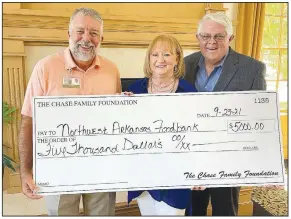  ?? (Courtesy Photo) ?? Kent Eikenberry, president and chief executive officer, Northwest Arkansas Food Bank, accepts a check representi­ng a $5,000 donation from the Chase Foundation. Representi­ng the Chase Foundation are Susan Chase and John Bakker. The Chase Foundation helps fight food insecurity in older adults.