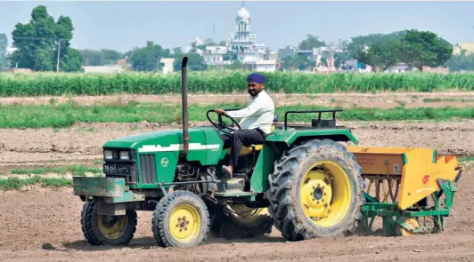  ?? AKHILESH KUMAR ?? A FARMER SOWING paddy seeds using a direct seeding machine at Pannuan village on the outskirts of Mohali in Punjab on June 10.