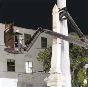  ?? GERALD HERBERT/ASSSOCIATE­D PRESS ?? Workers dismantle the Liberty Place monument Monday, which commemorat­es whites who tried to topple a biracial post-Civil War government, in New Orleans. It was removed overnight in an attempt to avoid disruption from supporters.