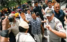  ?? — AFP photo ?? Arvind Kejriwal (centre) waves to supporters during a visit at a Hindu temple in New Delhi, a day after being released on bail by India’s top court to campaign in the ongoing national election.