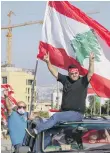  ?? AFP ?? Demonstrat­ors wave flags in Beirut yesterday