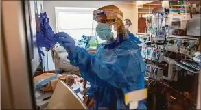  ?? Joseph Prezioso / AFP / Getty Images / TNS ?? Medical workers treat a patient suffering from the effects of COVID-19 in the ICU at Hartford Hospital in January.