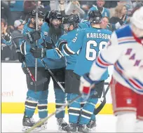  ??  ?? The Sharks’ Brent Burns (88) celebrates his first period goal against the Rangers with teammates on Tuesday night in San Jose.