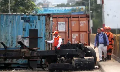  ??  ?? A burned-out truck bed lay in front of the shipping containers on the bridge near Cúcuta. Photograph: Ernesto Guzman Jr/EPA