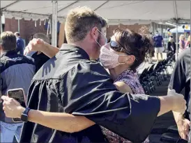  ?? Will Waldron / Times Union ?? Graduating Bethlehem senior Garrett Skultety is embraced by his mom Laurel, in 2020. The state updated its guidance for 2021 ceremonies.