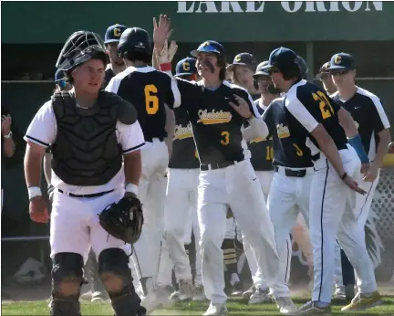  ?? MATTHEW B. MOWERY — MEDIANEWS GROUP ?? The Clarkston dugout congratula­tes Luke Spicer (6) after he scored the go-ahead run in a 2-1win over Lake Orion on Monday. Lake Orion led the nightcap 2-1 when it was suspended after four innings.