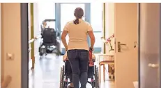  ?? FOTO: DPA ?? Eine Pflegerin schiebt eine ältere Frau im Rollstuhl durch den Flur eines Krankenhau­ses. Für Kliniken wird es immer schwierige­r, Personal zu finden.