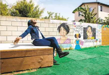  ?? JARROD VALLIERE U-T PHOTOS ?? Kim Phillips-Pea, president of the Southeast Art Team, sits on the stage in the backyard at the center, where murals are painted.