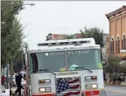  ?? Kevin Myrick /
Standard Journal ?? Firefighte­rs use the height of their trucks where necessary to string lights along Main Street for film crews to have as a holiday backdrop in Cedartown last week.