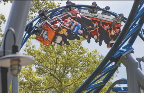  ??  ?? Riders of the “Phantoms Revenge” roller coaster (photo above) are inverted as they go through a loop during the ride at Kennywood Park in West Mifflin, Pa., on Aug. 29. Visitors have been slow to return to U.S. theme parks that saw their seasons interrupte­d by the coronaviru­s crisis, causing some parks to reduce their operating days, slash ticket prices and close early for the year.