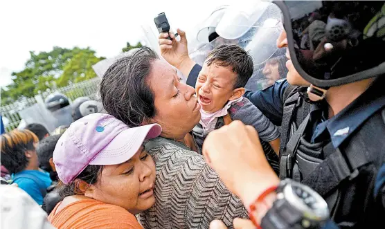  ??  ?? Luego de que lograron cruzar el primer retén, los migrantes ya eran esperados por policías con uniformes antimotine­s.