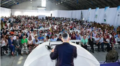  ?? (Shahar Azran) ?? TONY GELBART, chairman and co-founder of Nefesh B’Nefesh, addresses new immigrants at Ben-Gurion Airport yesterday morning.