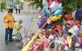  ?? SCOTT OLSON/GETTY ?? People gather Wednesday at a makeshift memorial outside the Tops supermarke­t in Buffalo, New York, where 10 Black people were killed by gunfire last Saturday.