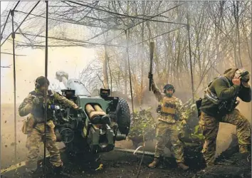  ?? Roman Chop ?? “THE MAIN IDEA is to exhaust them, then to attack,” a Ukrainian officer said of the fight for Bakhmut. Ukraine is chipping away at Russia’s hold on the city. Above, Ukrainian soldiers fire a howitzer D-30.