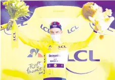  ?? - AFP photo ?? Alaphilipp­e celebrates his overall leader yellow jersey on the podium after winning the 2nd stage of the 107th edition of the Tour de France cycling race, 187 km between Nice and Nice.