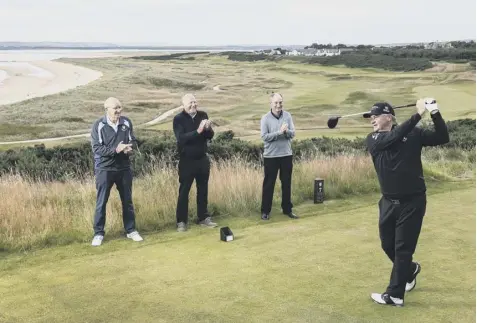  ??  ?? 0 Members watch as Paul Lawrie tees off at the redesigned 7th hole on the Championsh­ip course at Royal Dornoch.