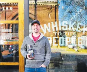  ?? STAFF PHOTO BY ERIN O. SMITH ?? Chattanoog­a Whiskey Co. co-founder and CEO Tim Piersant holds a bottle of Chattanoog­a Whiskey outside the company’s Tennessee Stillhouse on Market Street.