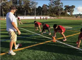  ?? SHERRY LAVARS — MARIN INDEPENDEN­T JOURNAL ?? San Rafael High head football coach Mark Lubamersky works with members of his offensive line during practice on Friday. The state has lifted the ban on outdoor competitiv­e youth sports.