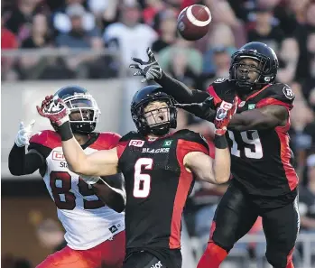  ?? JUSTIN TANG/THE CANADIAN PRESS ?? Redblacks defensive backs Imoan Claiborne, right, and Antoine Pruneau reach for a ball intended for Stampeders receiver DaVaris Daniels in the Calgary end zone Friday night at TD Place.