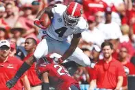  ?? AP PHOTO/JOSHUA L. JONES ?? Georgia wide receiver Mecole Hardman (4) leaps over South Carolina’s J.T. Ibe during the first half of Georgia’s 41-17 SEC victory Saturday in Columbia, S.C.