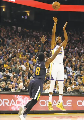  ?? Photos by Stephen Lam / Special to The Chronicle ?? Forward Kevin Durant attempts a three-point shot over Shelvin Mack of the Jazz. Durant scored 16 points for the second straight game after returning from his left knee injury.