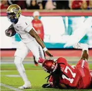  ?? ?? Tulsa quarterbac­k Braylon Braxton escapes getting sacked by UH’s Atlias Bell during the first half.