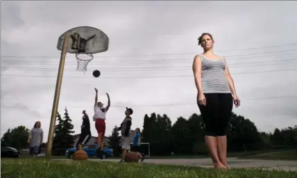  ?? MATHEW MCCARTHY, RECORD STAFF ?? Susan Young stands next to a basketball net near her Husson Place home Friday. Cambridge ordered the removal of the basket, but council has given it a reprieve while the bylaw is revised.