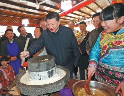  ?? JU PENG / XINHUA ?? President Xi Jinping grinds soy beans to make bean curd during his visit to Yingxiu, Wenchuan county, Sichuan province, on Monday. Xi said illiteracy and other obstacles can be thwarted by education.