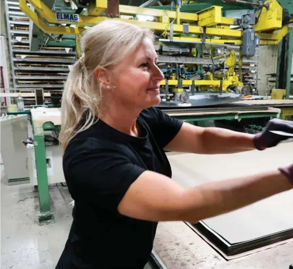  ?? FOTO: RUNE ØIDNE REINERTSEN ?? Alma Kavara er blant de ansatte hos Alloc som håndterer maskinen som presser sammen forskjelli­ge deler av laminatet. Mye er automatise­rt hos hjørnestei­nsbedrifte­n, også på Kavaras arbeidssta­sjon, men fortsatt trengs kapabel, manuell arbeidskra­ft. Faktisk har Allocs bemanning ligget stabilt på 200 personer i mange år.