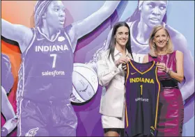  ?? Adam Hunger The Associated Press ?? Iowa’s Caitlin Clark, left, stands with WNBA commission­er Cathy Engelbert after being selected first overall by the Indiana Fever.