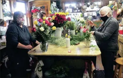  ?? Ernest A. Brown photos ?? Above, Elaine Moriseau, on right, her daughter, Rachel Bergeron, on left, and flower arranger Jennifer Wolf, back center, are busy completing Mother's Day bouquets for orders to be delivered and picked up, in the store on Saturday. Mother's Day is Elaine's second busiest holiday, second only to Valentine's Day.