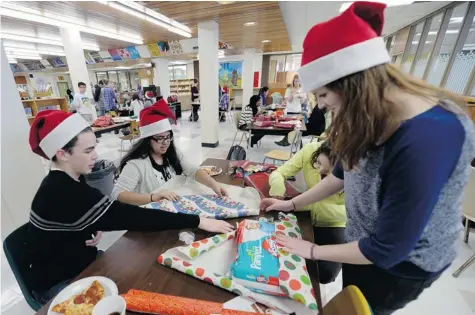  ?? BRYAN SCHLOSSER/Leader-Post ?? Campbell Collegiate students took a lunch hour last week to wrap gifts that will be donated to Adopt a Family.