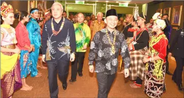  ??  ?? Maszlee (right), Awang Tengah and others welcomed by Unimas students in their traditiona­l attires upon their arrival for the function.