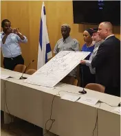  ?? (Oren Oppenheim) ?? AVERA MENGISTU’S PARENTS (center) and MK Hilik Bar (right) pose with artwork dedicated to Avera.