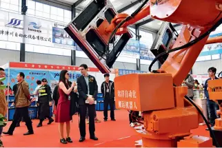 ?? Cnsphoto ?? 24 de abril de 2018. Dos funcionari­os de la Embajada de España en China se presentan en la XI Exposición Internacio­nal Sino-Dongguang de Maquinaria de Envasado de Cartón, en el distrito de Dongguang, provincia de Hebei.
