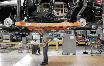  ??  ?? A chassis assembly line supervisor checks a vehicle on the assembly line at the Chrysler Jefferson plant in Detroit. A rebound in business spending, export growth and a sharp moderation in the pace of decline in government outlays boosted US economic...