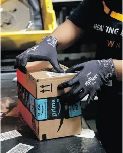  ?? BESS ADLER / BLOOMBERG ?? An employee packs a box at an Amazon.com Inc. fulfillmen­t centre. A bigger Prime Day is set for July 16.