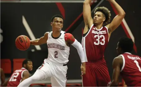  ?? NAncy lAnE PHoToS / HErAld STAFF ?? LOOK QUICK: Northeaste­rn’s Tyson Walker passes around UMass’ Tre Mitchell during the Huskies’ 78-75 win on Sunday at the Cabot Center.