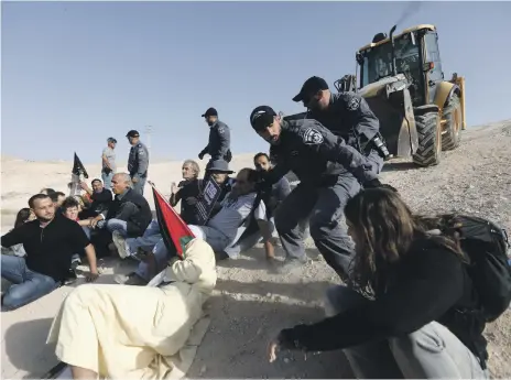  ?? EPA ?? Israeli forces detain activists at the Palestinia­n Bedouin village of Khan Al Amar yesterday. Israel planned to demolish Khan Al Amar, located between the West Bank city of Jericho and Jerusalem, yesterday, but the activists blocked the bulldozers