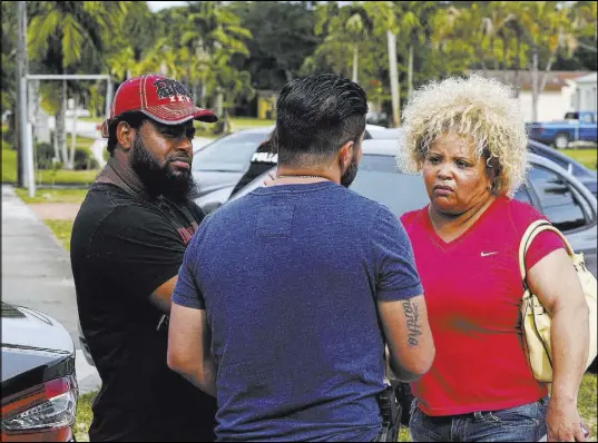  ??  ?? Miami-Dade police Sgt. Carlos Luffi, center, tells Valentina De Leon and her husband that police cannot remove suspected squatters from their Miami house.