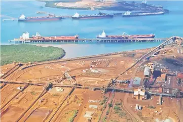  ??  ?? Ships waiting to be loaded are seen near piles of iron ore and bucket-wheel reclaimers at the Fortescue loading dock located at Port Hedland in the Pilbara region of Western Australia. Australia’s government expects the nation’s resource and energy exports to hit a record of A$252 billion (US$182 billion) in 2018-2019, buoyed by climbing prices for commoditie­s such as natural gas and by a weaker Australian dollar. — Reuters file photo