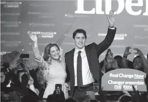  ?? Photo Chris Wattie/Reuters ?? Liberal Party leader Justin Trudeau, accompanie­d by his wife Sophie Gregoire, celebrate his victory with supporters. ().